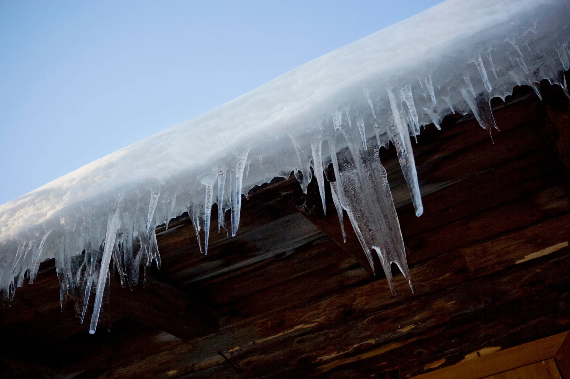 Large icicles hanging from a home's roofline in winter in Woodbury, MN