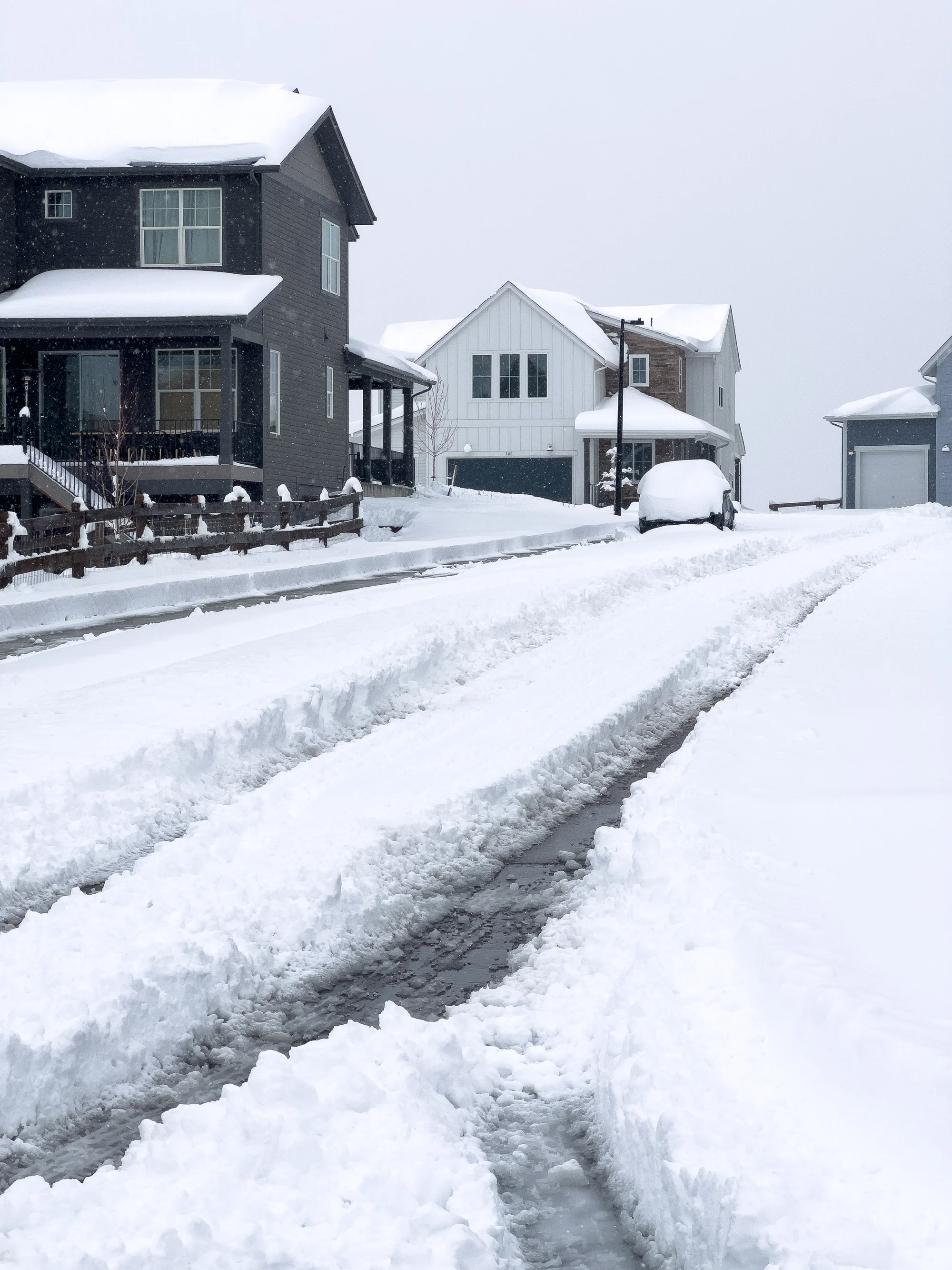 Tire tracks in fresh snow on a plowed Maplewood, MN driveway